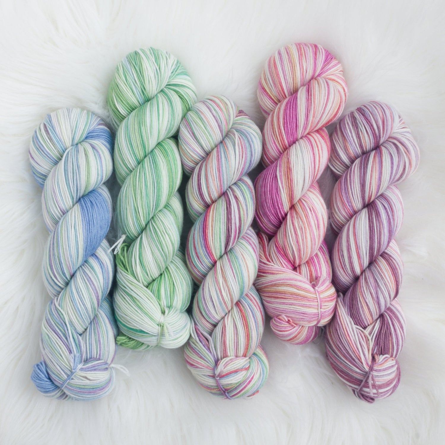 Five skeins of yarn on a sheepskin background
